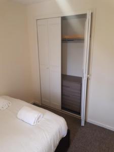 IfieldMarvellous Meridian Maisonette的卧室配有白色的床和衣柜。