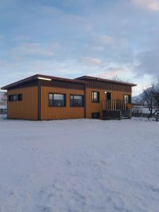 ÞingeyrarMidhop guesthouse的雪中的房子