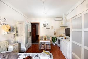 彼得拉桑塔La Bomboniera Chic di Pietrasanta的厨房配有白色橱柜和桌子