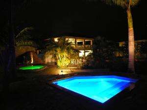帕拉蒂加巴库阿拉海滩度假酒店的游泳池,后方是一座房子