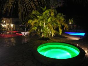 帕拉蒂加巴库阿拉海滩度假酒店的夜晚在院子里的绿色泳池