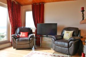 丁格尔Ard na Carraige, Ventry Holiday Home的客厅配有两把椅子和电视