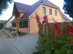 欧巴德伍斯图Ferienwohnung Thum的一座带围栏和粉红色花卉的房屋
