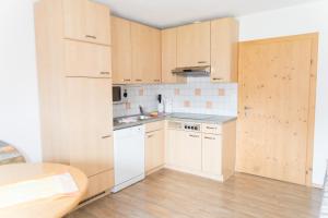 洛伊塔施劳斯公寓的厨房配有白色家电和木制橱柜