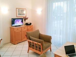 岑平Apartment Fridolin的客厅配有椅子和电视