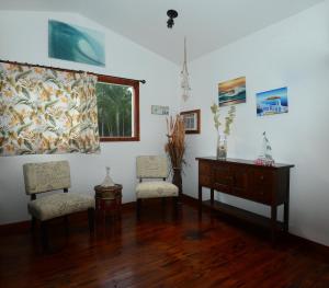 普普科亚夏威夷卡拉尼私人乡村民宿的客房设有两把椅子、一张桌子和一个窗户。