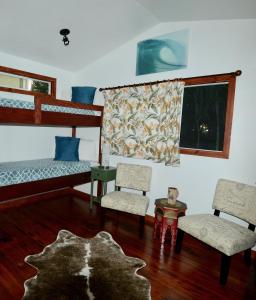 普普科亚夏威夷卡拉尼私人乡村民宿的一间卧室配有两张双层床和两把椅子