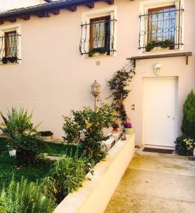 维琴察Papere e Tulipani的白色的房子,有白色的门和一些植物