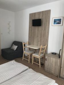 塔查斯卡-鲁穆尼卡Vila Bellis的一间卧室配有一张床、一张桌子和一张沙发