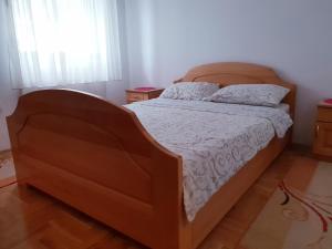 兹拉蒂博尔Apartment Caka的一间卧室配有一张大床和木制床头板