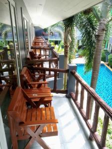 奥南海滩奥南乡村度假酒店的一个带游泳池的阳台的一排躺椅