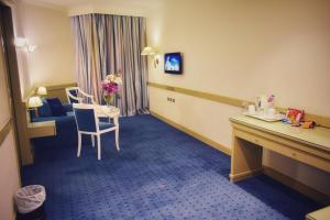 亚历山大Romance Alexandria Hotel的酒店客房带桌子、椅子和房间