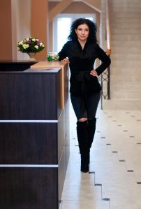 第聂伯罗Prestige Apartments Kalnyshevskogo的身穿黑色衣服的女人,靠在柜台上