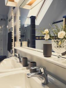 安纳贝格-伦格茨Postwirt Annaberg的浴室水槽,配有镜子和花瓶