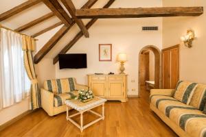威尼斯丽都拉古纳别墅酒店的客厅配有两张沙发和一台电视机