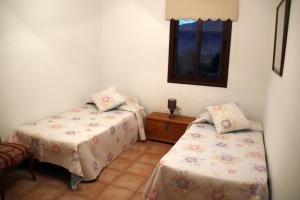 洛斯·亚诺斯·德·阿里丹Casa Clotilde的客房设有两张床和窗户。