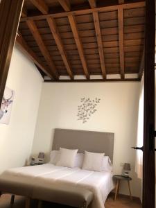 钦琼El Patrón的卧室配有白色床和木制天花板