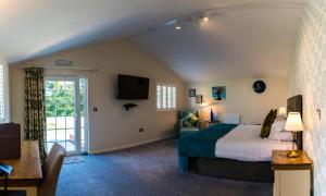 布里德灵顿Manor Court Hotel的一间卧室配有一张床、一张沙发和一台电视。