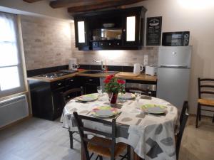圣艾尼昂GITE DE LA PECHERIE的厨房配有桌椅和冰箱。