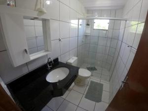 邦比尼亚斯Casa em Bombinhas的白色的浴室设有水槽和卫生间。