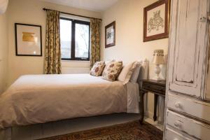 格拉斯顿伯里Dilkara Apartment Glastonbury的卧室配有白色的床和窗户。