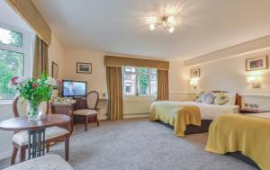 科尔雷恩Bushtown Hotel & Spa的酒店客房设有两张床和一张桌子。