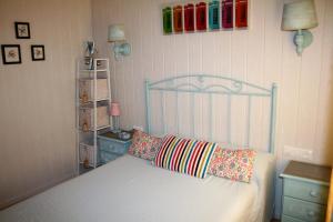 巴尔巴特Don Pelayo的一间卧室配有床和一个带色彩缤纷枕头的架子。
