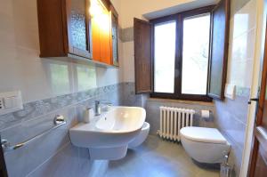 阿西西All'Ombra di San Damiano的一间带水槽和卫生间的浴室以及窗户。