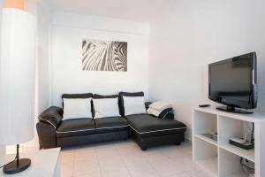阿马多拉In Bed with Lisbon 7D的客厅配有黑色真皮沙发和电视