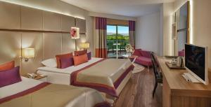 欧库卡拉Botanik Hotel的酒店客房配有两张床和一张书桌