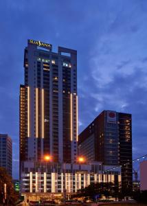 新山Suasana Suites Hotel Johor Bahru的一座高大的建筑,上面有沙姆星标志