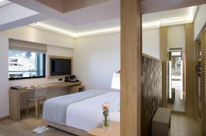雅典雅典黄金时代酒店的酒店客房配有一张床、一张书桌和一台电视。