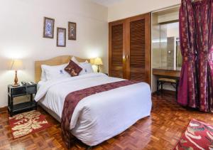 内罗毕Chester Hotel and Suites Nairobi, City Centre CBD的一间卧室配有一张大床和一张书桌