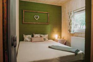 SirokVackorkert的一间卧室配有一张带绿色墙壁的床