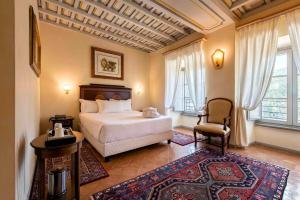 卡纳莱蒙特拉诺Hotel Terme di Stigliano的一间卧室,卧室内配有一张床和一把椅子