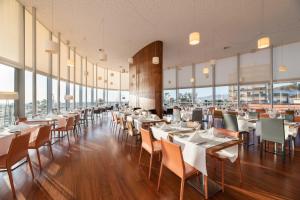 菲盖拉-达福什欧洲之星绿洲广场酒店的餐厅设有桌椅和大窗户。