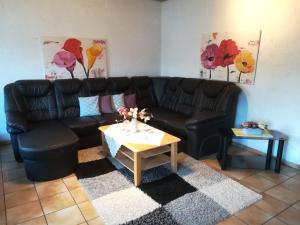 阿滕多恩Flat with private pool in Sauerland的客厅配有黑色真皮沙发和咖啡桌