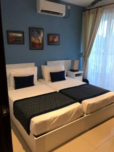 亭可马里Beach Paradise Nilaveli的一间卧室设有两张床和蓝色的墙壁