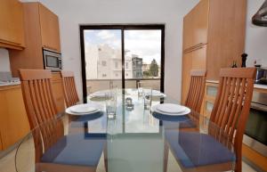 圣朱利安斯City Living Suite Tk 3 Rm 4的一间设有玻璃桌和椅子的用餐室