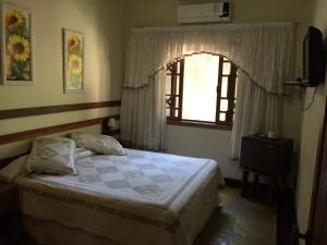 尼泰罗伊Pousada Praia de Itacoatiara的一间卧室设有一张床和一个窗口
