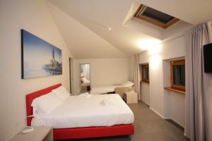 维罗纳StraVagante Hostel & Rooms的酒店客房带白色的床和红色长凳