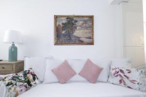 博洛尼亚Charming and cosy apartment的一张带枕头的白色床和墙上的照片