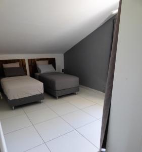埃唐萨莱莱班海滩Bel appartement spacieux的卧室配有两张床,铺有白色瓷砖地板。