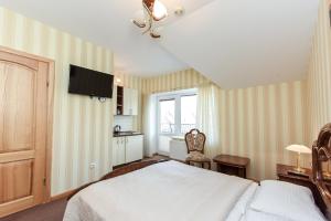 帕兰加维拉莱维塔酒店的卧室配有一张床,墙上配有电视。