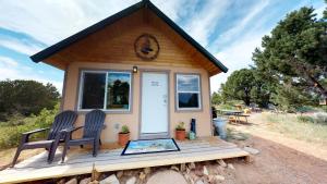 蒙蒂塞洛White Pine Cabin by Canyonlands Lodging的门廊上带两把椅子的小房子