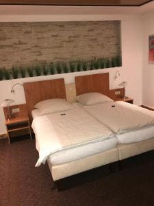 威廉港tauwerk Hotel的一间卧室设有两张床,墙上有植物