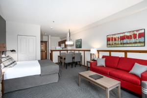 蒙特朗布朗旅行者酒店的酒店客房,配有一张床和一张红色的沙发