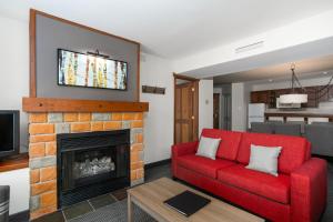 蒙特朗布朗旅行者酒店的客厅设有红色的沙发和壁炉