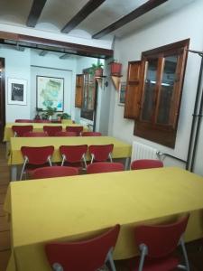 阿尔巴拉辛Albergue Albarracín的一间会议室,配有黄色桌子和红色椅子