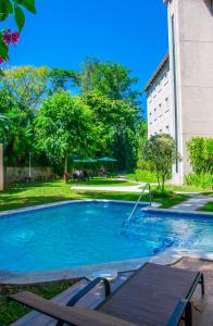圣萨尔瓦多Hotel Gardenia Inn的一座游泳池,位于一座建筑旁的院子内